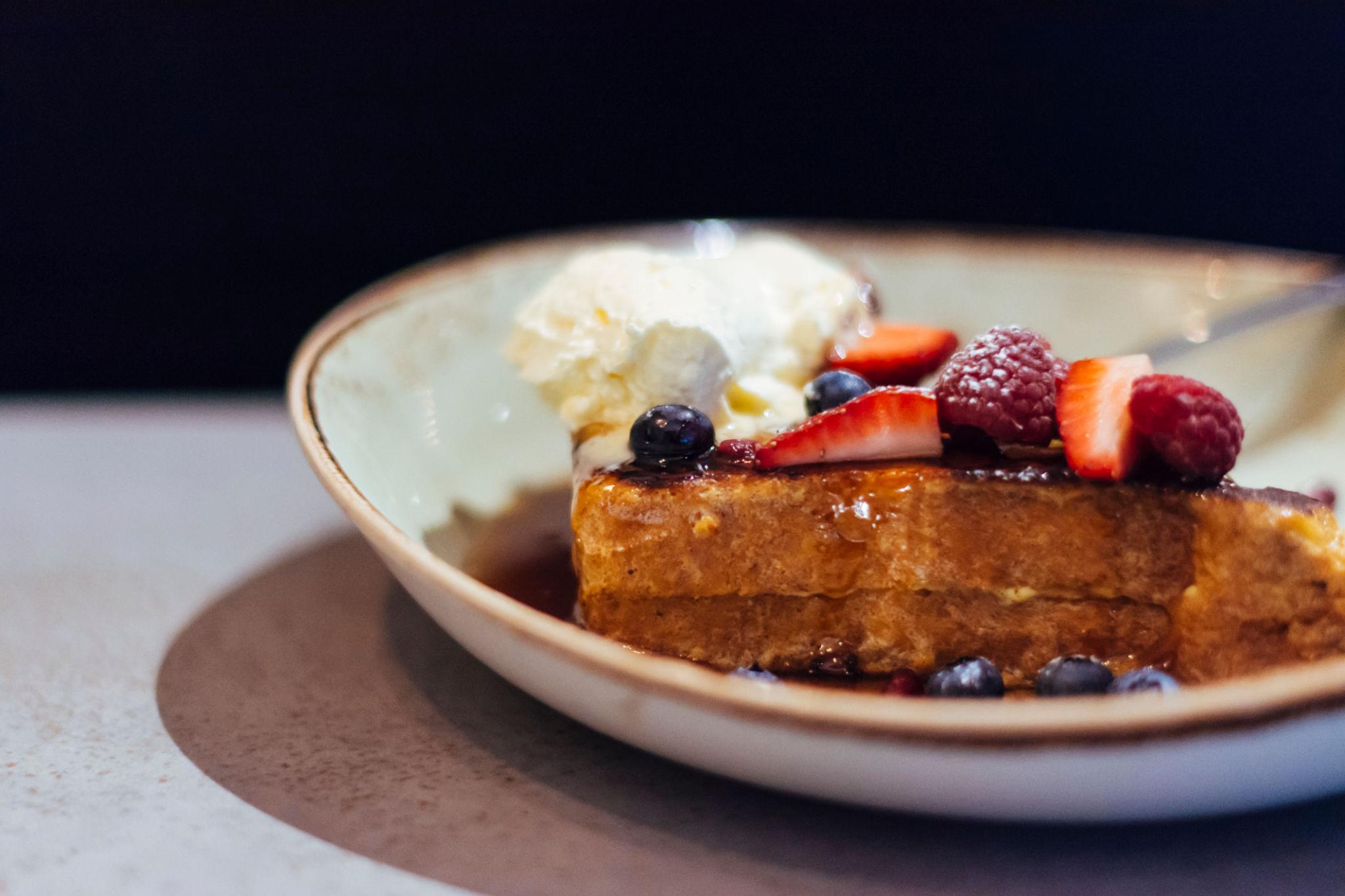 Gourmet scratch-made brunch featuring French toast with fresh berries and whipped ricotta