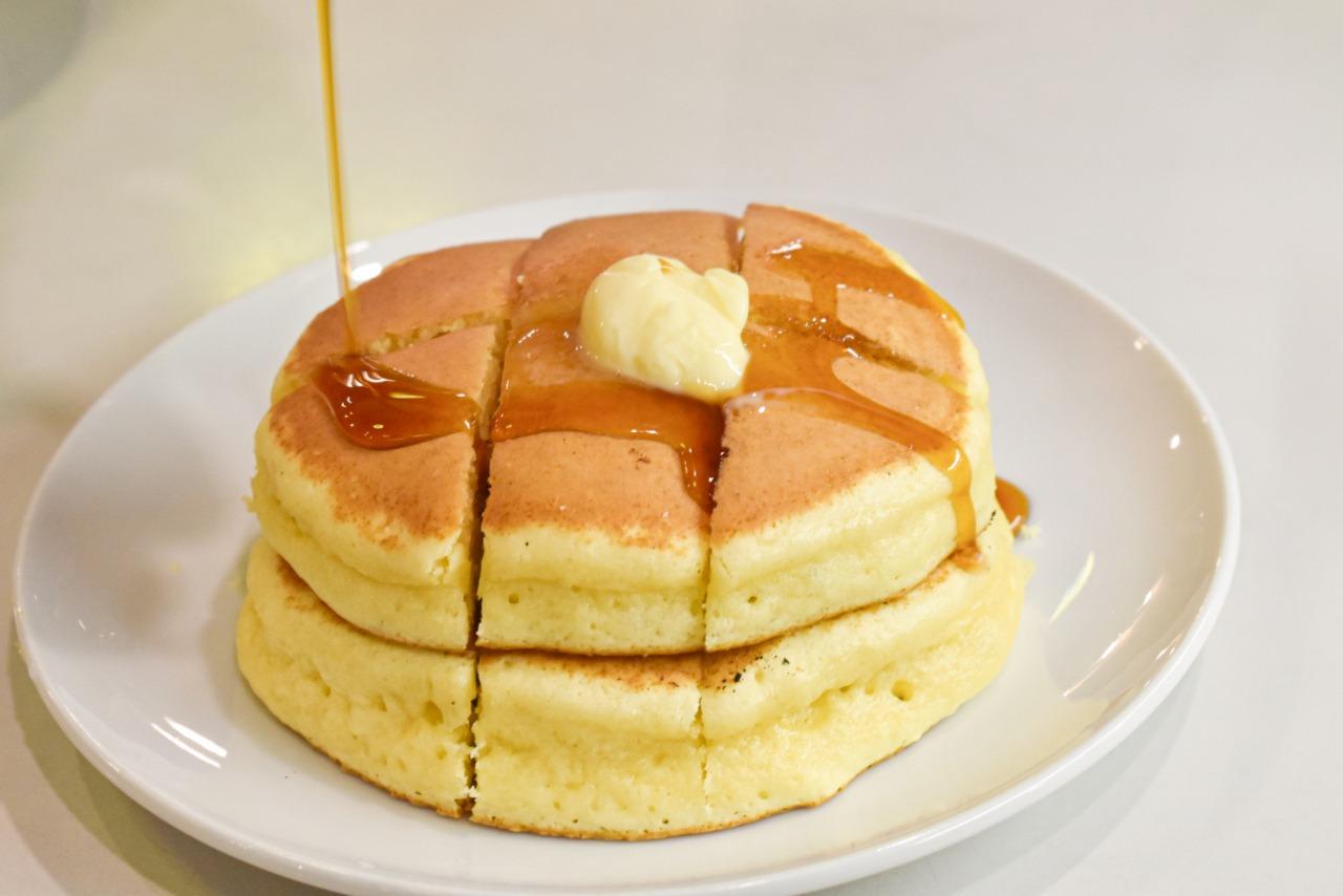 Fluffy pancakes topped with honey butter and fresh lemon zest